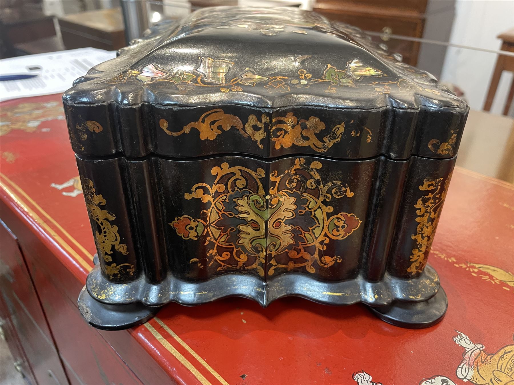 Victorian black lacquered papier-mâché sewing box, of rectangular form with shaped sides, the slightly domed top with inlaid mother of pearl and abalone decoration, the sides with gilt and polychrome painted scrollwork, the hinged cover opening to reveal a fitted interior with lift out tray, H14cm