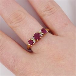 9ct gold ruby and diamond ring, three oval cut rubies spaced by six accent diamonds, stamped 9k