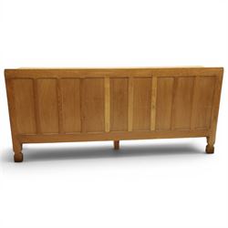 Mouseman - large adzed light oak sideboard, the rectangular top with raised galleried back, fitted with three central drawers flanked by panelled cupboards enclosing shelves, with wrought iron fittings, raised on octagonal feet, with signature carved mouse, by the workshop of Robert Thompson, Kilburn