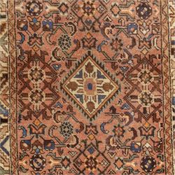 North West Persian Malayer hand-knotted runner, camel pink field decorated with an all-over lattice of Herati design, composed of rosettes and enclosed by angular leaves and stylized fish motifs, principal border of ivory ground decorated with stylized angular vine scroll and geometric palmettes, flanked by narrow guard stripes, with cotton fringe ends 