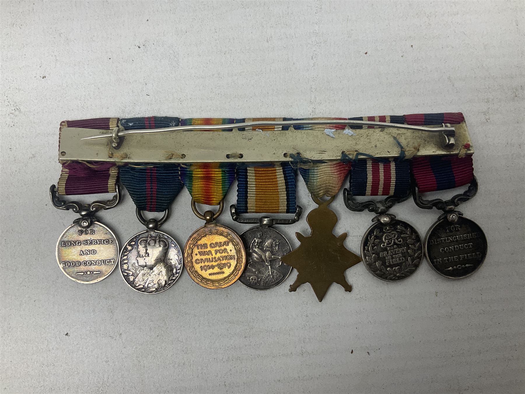 George V Military Medal and Distinguished Conduct Medal miniature group of seven medals comprising MM, DCM, WW1 trio including 1914 Star with date clasp and MID leaves, The Great Durbar Delhi 1911 Medal and LSGC; on pinned wearing bar; WW1 Military Medal miniature group of three comprising MM, BWM and Victory; Victoria North West Canada 1885 miniature; and George VI miniature Territorial Efficiency medal; all with ribbons