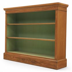 Traditional walnut small bookcase, with projecting cornice above a green painted interior, adjustable shelving, on a moulded plinth base