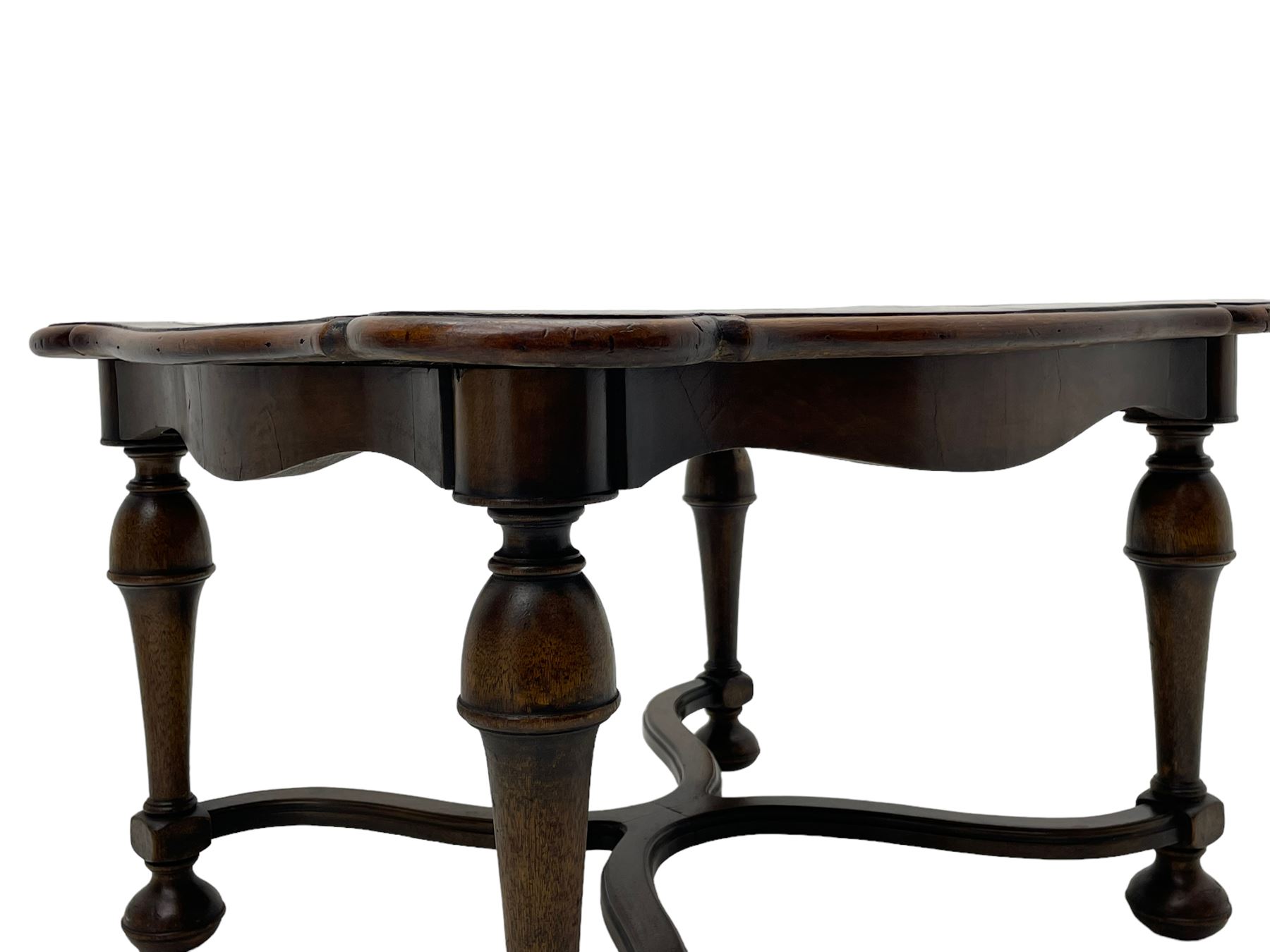 Figured mahogany coffee table, shaped moulded top with oval book-matched veneered panels, on turned supports united by waved X-shaped stretchers 