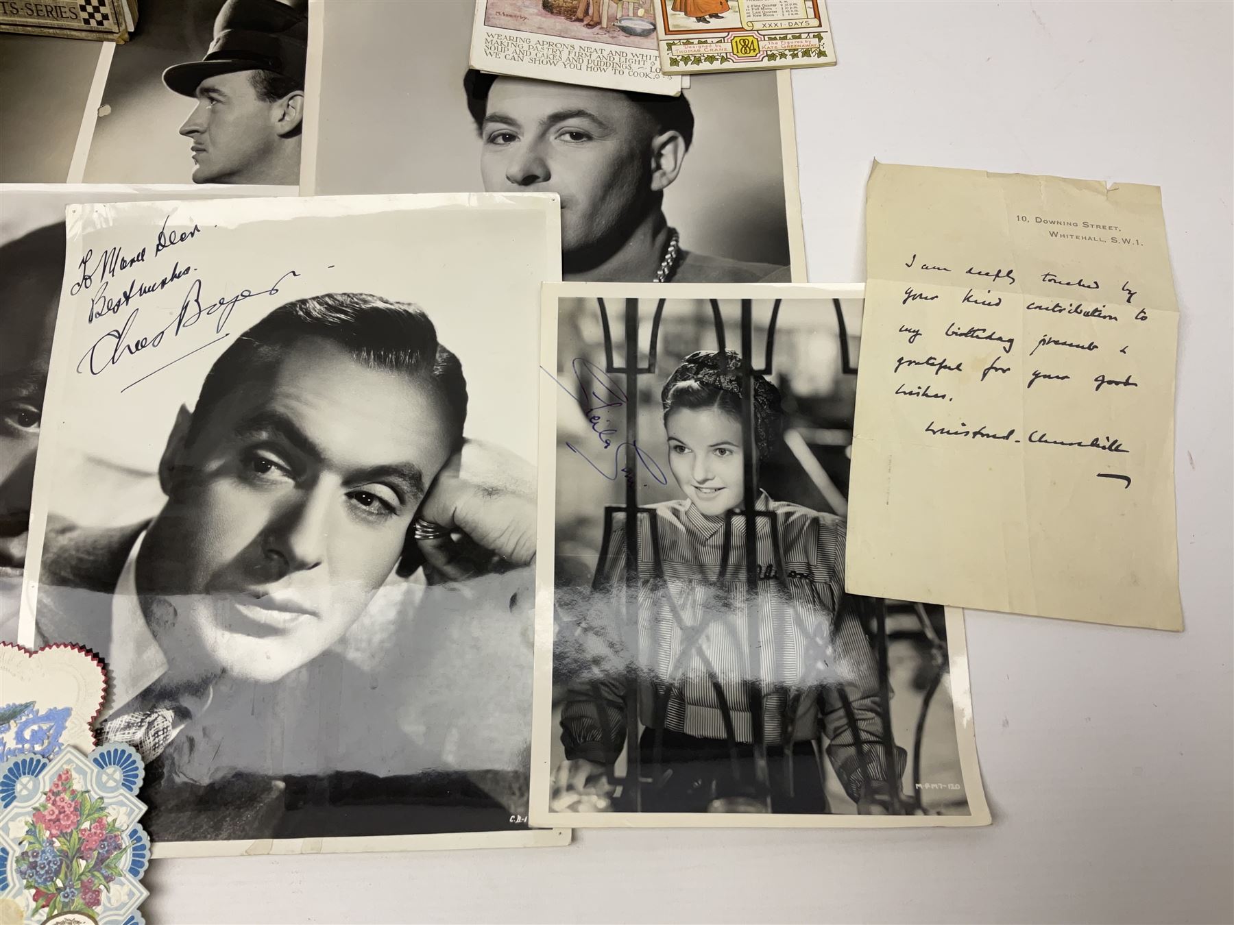 Early 20th century ephemera, to include signed photographs of Charles Boyer and Walter Pidgeon etc, a printed letter from Winston Churchill, two albums and a quantity of transfer books of Players and similar cigarette cards, including Boy Scout and Girl Guide Patrol Signs and Emblems and RAF Badges, a collection of greetings cards and postcards, a photograph album containing black and white photographs of Caius College Cambridge and guides and pamphlets on travelling Switzerland and the UK