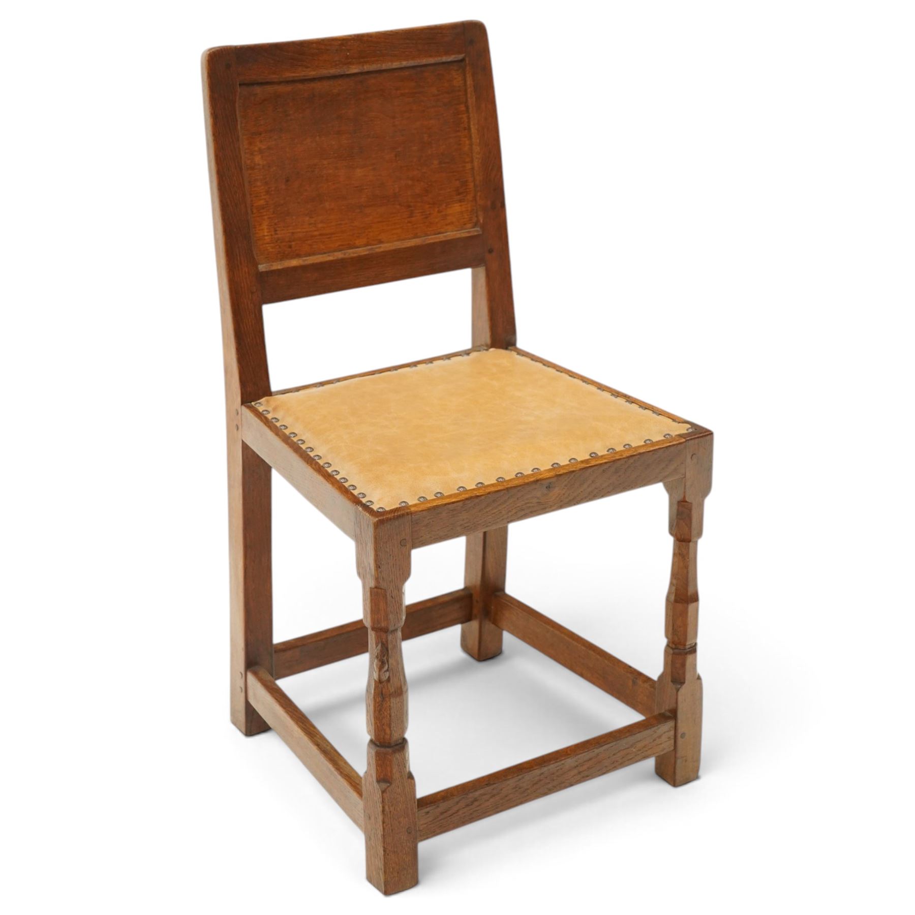 Mouseman side chair- panelled adzed back over tan leather upholstered seat with studwork, on octagonal front supports united by stretchers, each with signature carved mouse, by the workshop of Robert Thompson, Kilburn