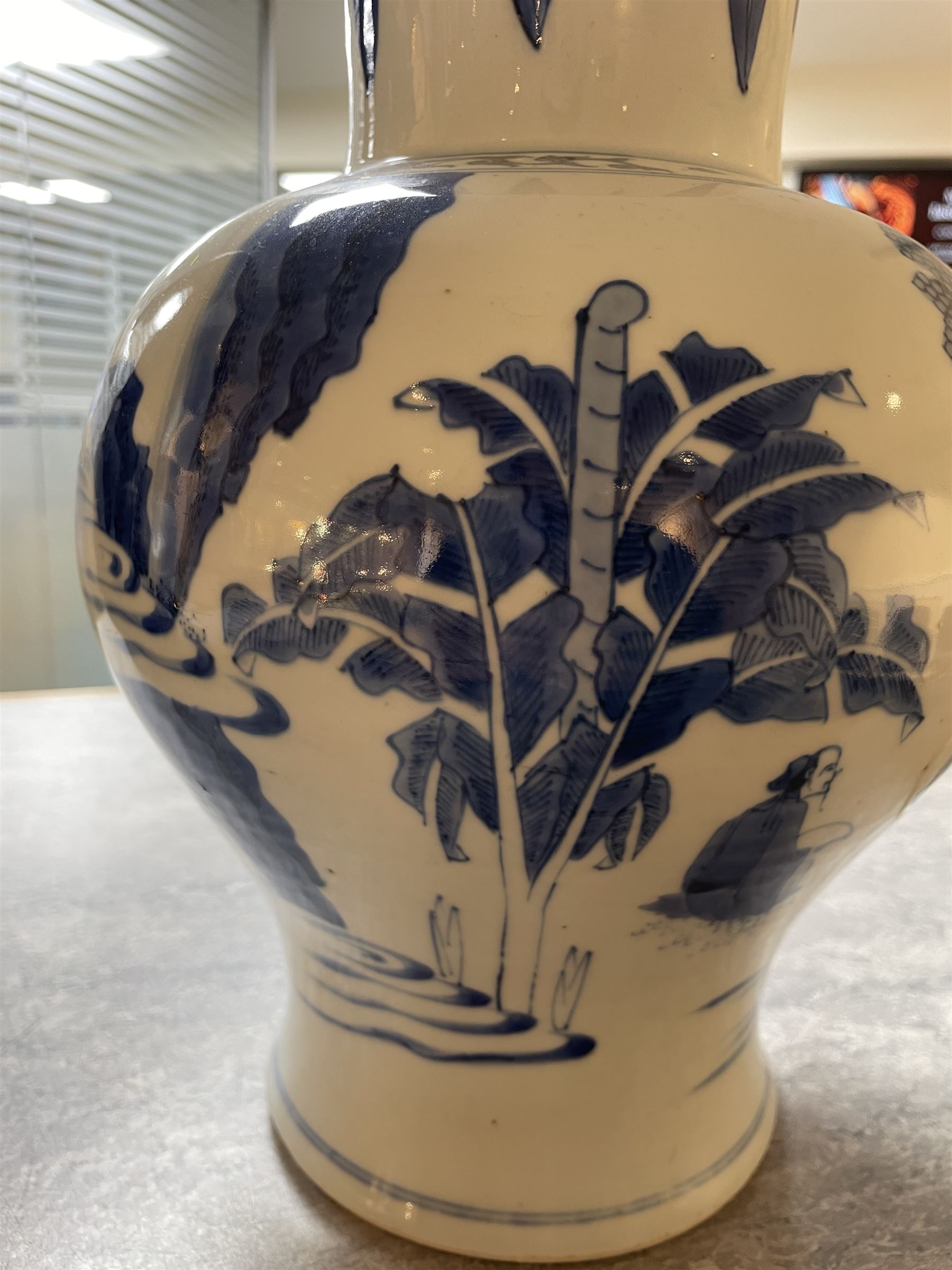 Pair of Chinese Kangxi blue and white porcelain vases, each of baluster form, painted with an outdoor scene containing figures seated upon the ground reading scrolls and holding fans, willow and bamboo tress, rock work and water, H27cm