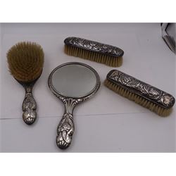 Edwardian silver mounted dressing table items, comprising hair brush, hand mirror and two clothes brushes, each repousse embossed with cherub groups, hallmarked with various dates and makers