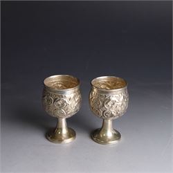 Pair of miniature Indian silver goblets, with embossed floral and foliate decoration, H6.5cm