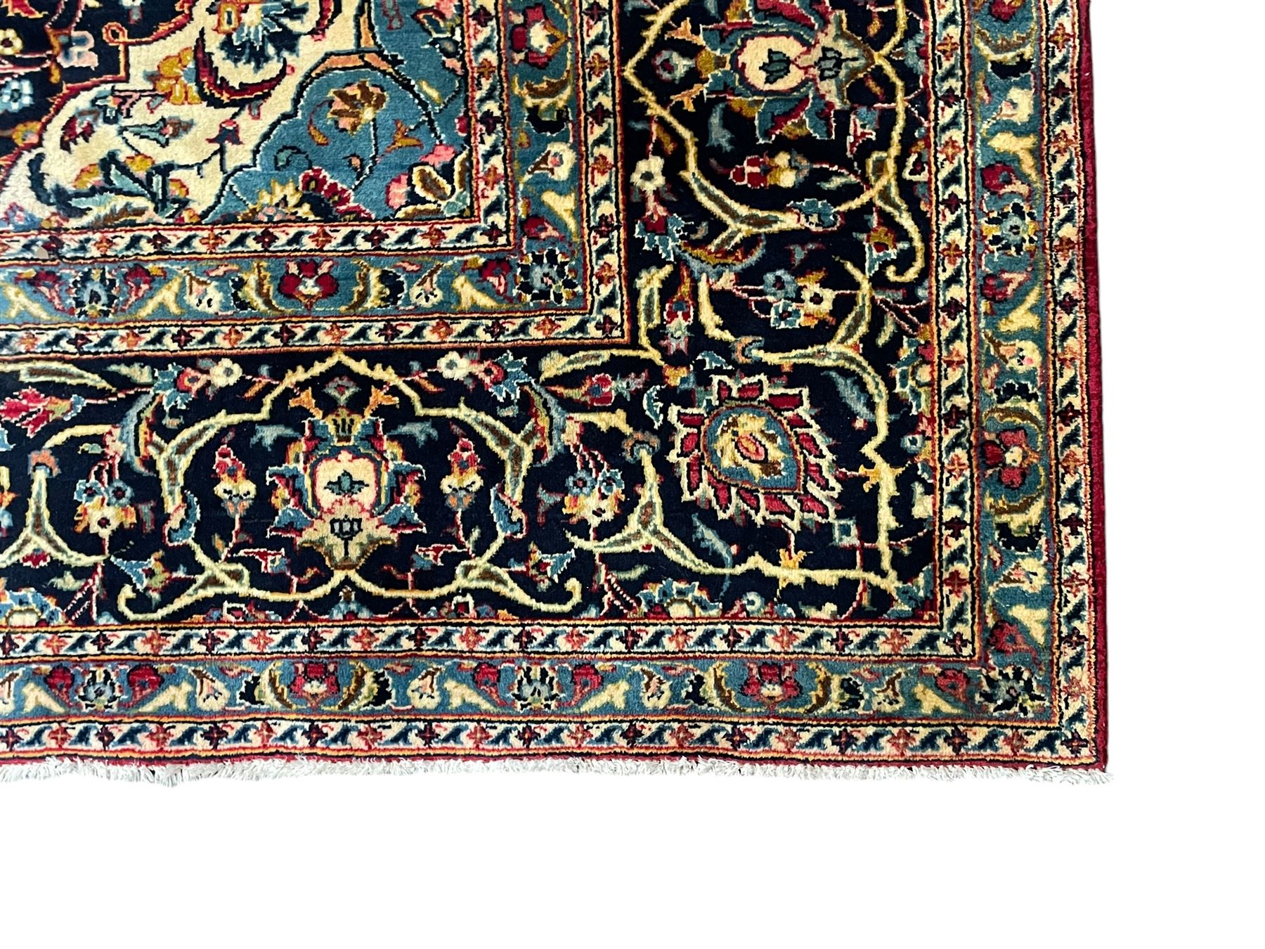 Persian Kashan crimson ground carpet, the central pole medallion decorated with flower heads, surrounded by trailing leafy branches and palmettes, scrolling border decorated with further palmettes, within floral pattern guard stripes 