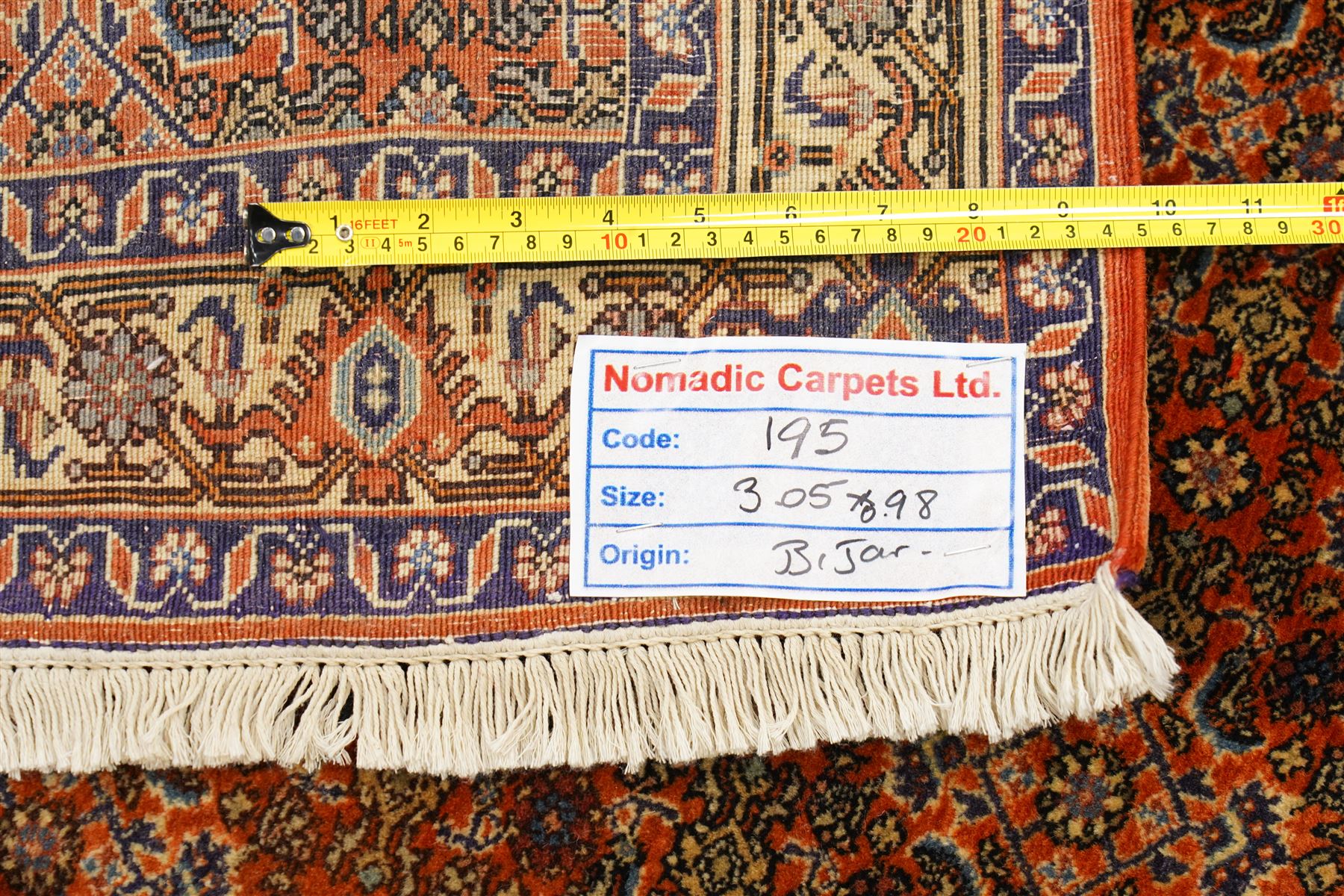 North West Persian Bidjar hand-knotted runner, terracotta field with a repeating mahi design of stylized rosettes and angular floral motifs within a lattice incorporating navy and ivory highlights, ivory principal border with a continuous angular vine of palmettes and serrated leaves, flanked b narrow guard brdoers, with cotton fringe ends 