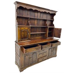 Traditional oak dresser, the moulded cornice over shaped apron, three heights plate rack fitted with two cupboards, the base fitted with six drawers and two double cupboards, panelled pointed ogee arched doors, on bracket feet