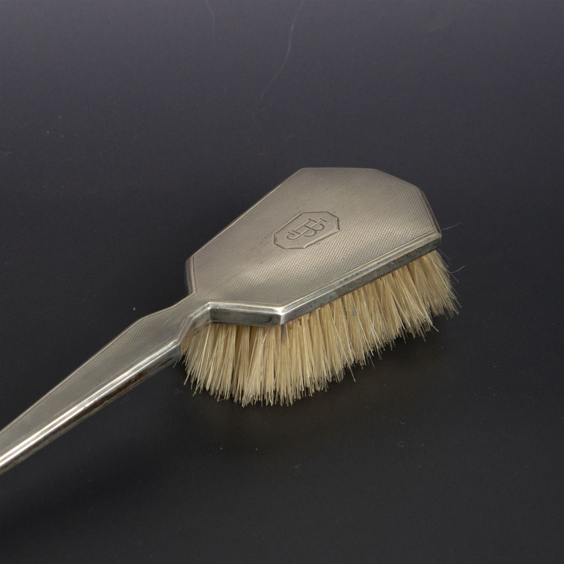 1930s silver mounted three piece dressing table set, comprising hand mirror, hair brush and clothes brush, hallmarked Barker Brothers Silver Ltd, Birmingham 1931