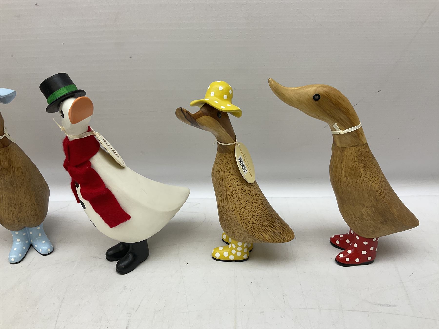 Quantity of the Duck Company UK DCUK carved bamboo root ducks, modelled wearing rain hats and rain boots etc, together with other similar carved wood ducks, tallest H26cm