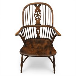 Late 19th century stained elm and beech Windsor armchair, the arched hoop back with pierced wheel splat above shaped lower splat between turned spindles, shaped arm rail on turned supports, saddle seat, raised on turned legs united by a crinoline stretcher