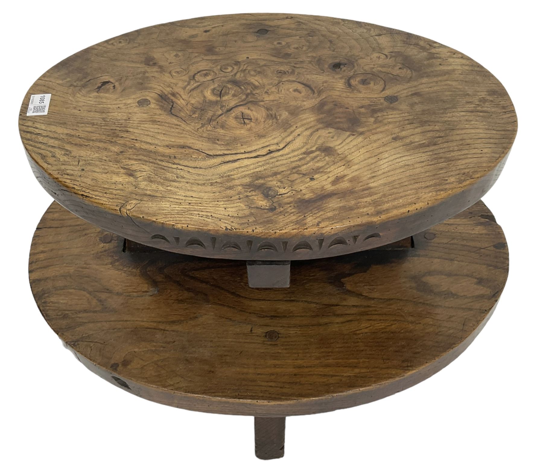 20th century figured elm occasional table, two oval tiers raised on cruciform base, the top tier carved with incised decoration 