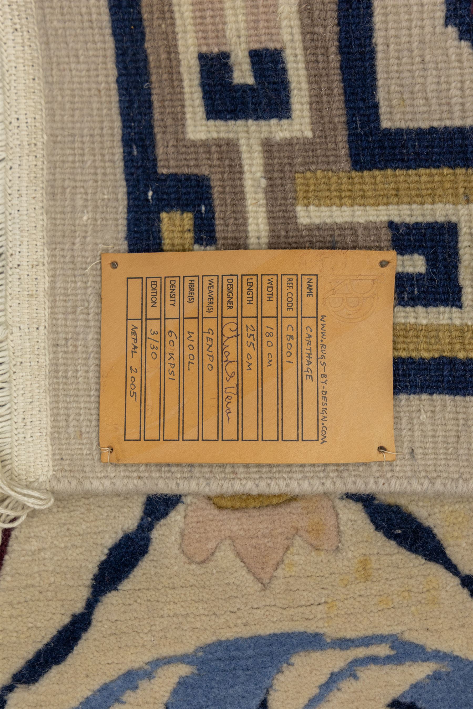 Rugs by Design - Nepalese wool rug, cream field decorated with repeating diamond trellis enclosing scrolling foliate motifs in blue, burgundy and ochre, within chain-link border and fringed ends