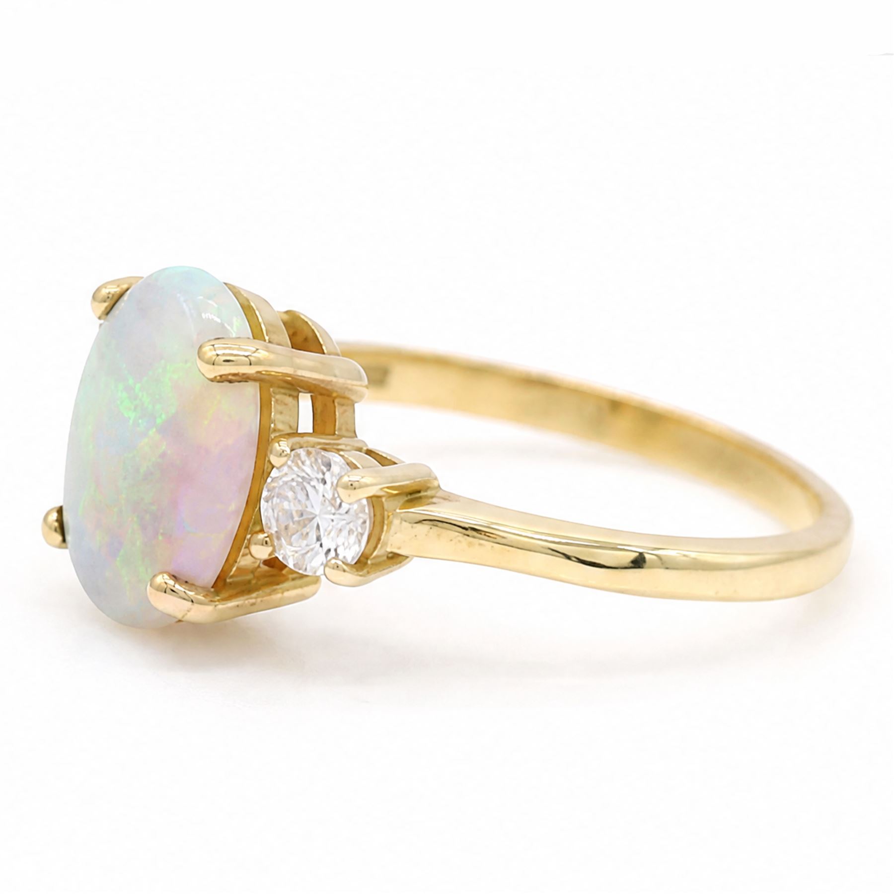 18ct god opal and diamond three stone ring, single oval cabochon cut opal of approx 2.80 carat, with a round brilliant cut diamond set either side, hallmarked, total diamond weight approx 0.25 carat