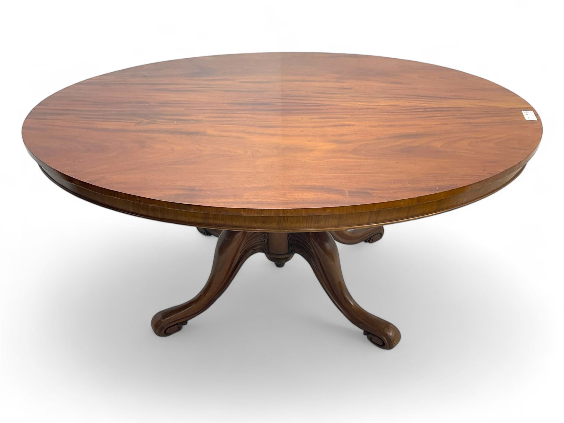 Victorian mahogany breakfast loo table, oval tilt-top on turned pedestal, quatrefoil out-splayed carved supports, scroll carved terminals with brass castors