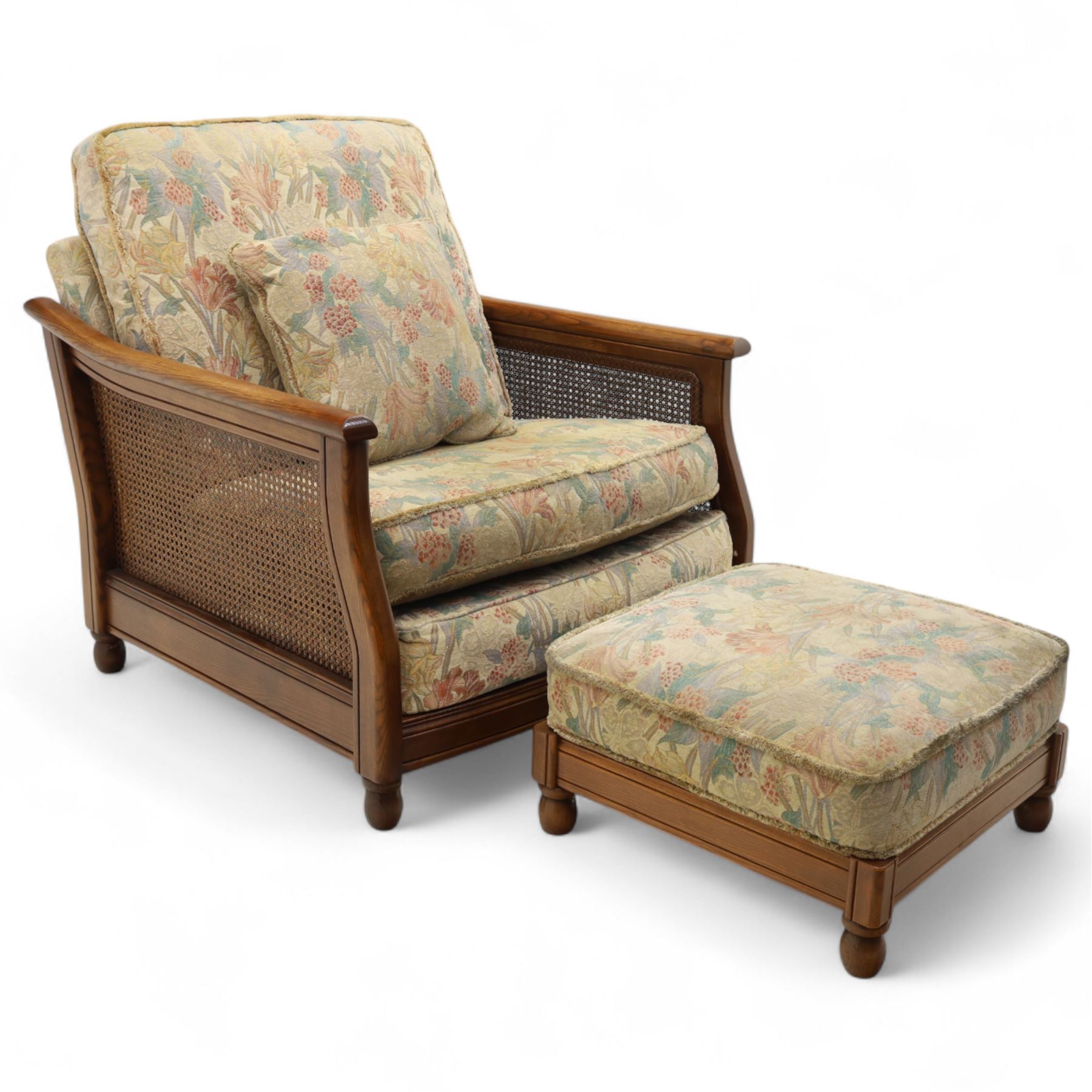 Ercol – bergère four piece suite, including armchair, two seat sofa, three seat sofa and footstool, all with removable floral upholstered cushions, the frames with side caning and rounded arm supports in stained beech

Three seat (H 87cm, D 89cm, W 196cm)
Two seat (H 87cm, D 89cm, W 137cm)
Armchair (H 87cm, D 89cm, W 87cm)
Footstool (H 28cm, D 55cm, W 55cm)