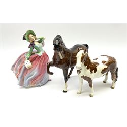 A Beswick Skewbald Pinto pony, together with a further Beswick horse model no 1549, and a Royal Doulton figure Autumn Breezes HN1911. (3). 