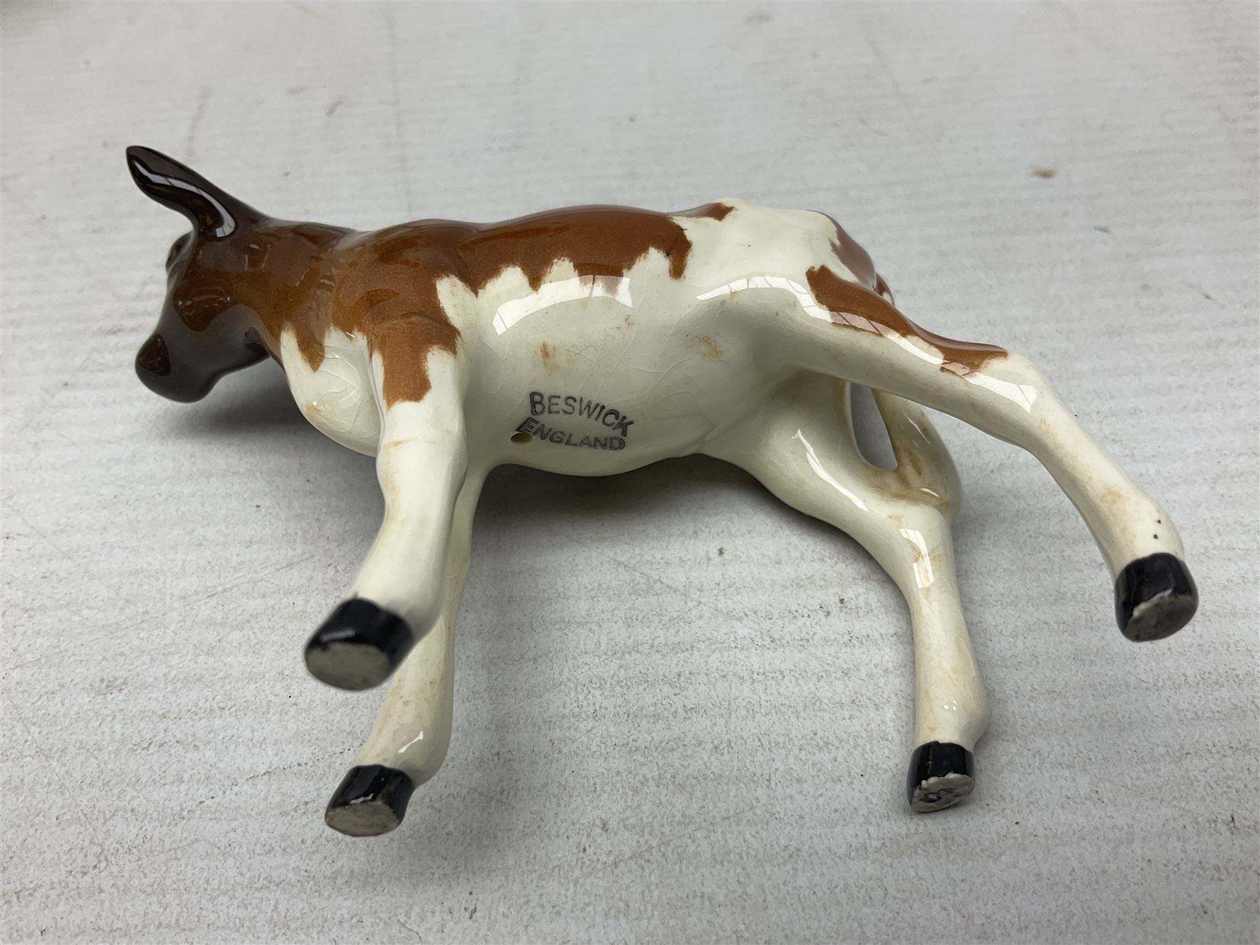 Five Beswick figures of cattle Comprising Ayrshire Bull Ch Whitehill Mandate, no 1454B, three Ayrshire Cow Ch Ickham Bessie, no 1350 and Ayrshire Calf, no 1249B, all with printed marks beneath