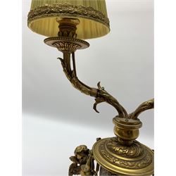 19th century French ormolu and champlevé twin branch table lamp, the stepped plinth base supporting an urn shaped body flanked by two putto, with twin acanthus detailed branches with foliate and beaded drip pans and sockets, with pleated gilt trimmed shades, including shades H47cm