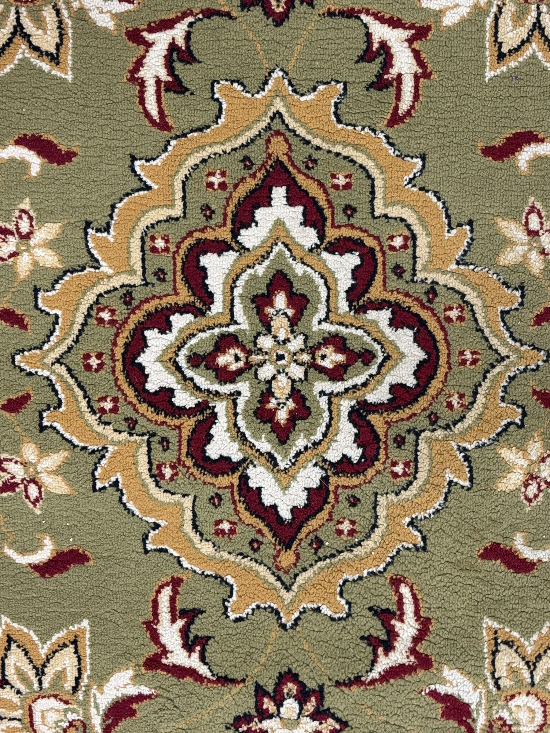 Turkish Sincerity Royale green ground rug, the field decorated with a central floral medallion surrounded by scrolling floral motifs in shades of cream, beige, and burgundy, spandrels filled with matching floral designs, the border featuring a series of floral patterns on a cream ground, finished with green edges