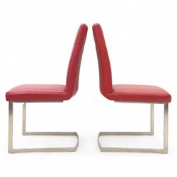 Set of seven contemporary style dining chairs, each with a high padded back and seat upholstered in faux leather on brushed steel sled bases  