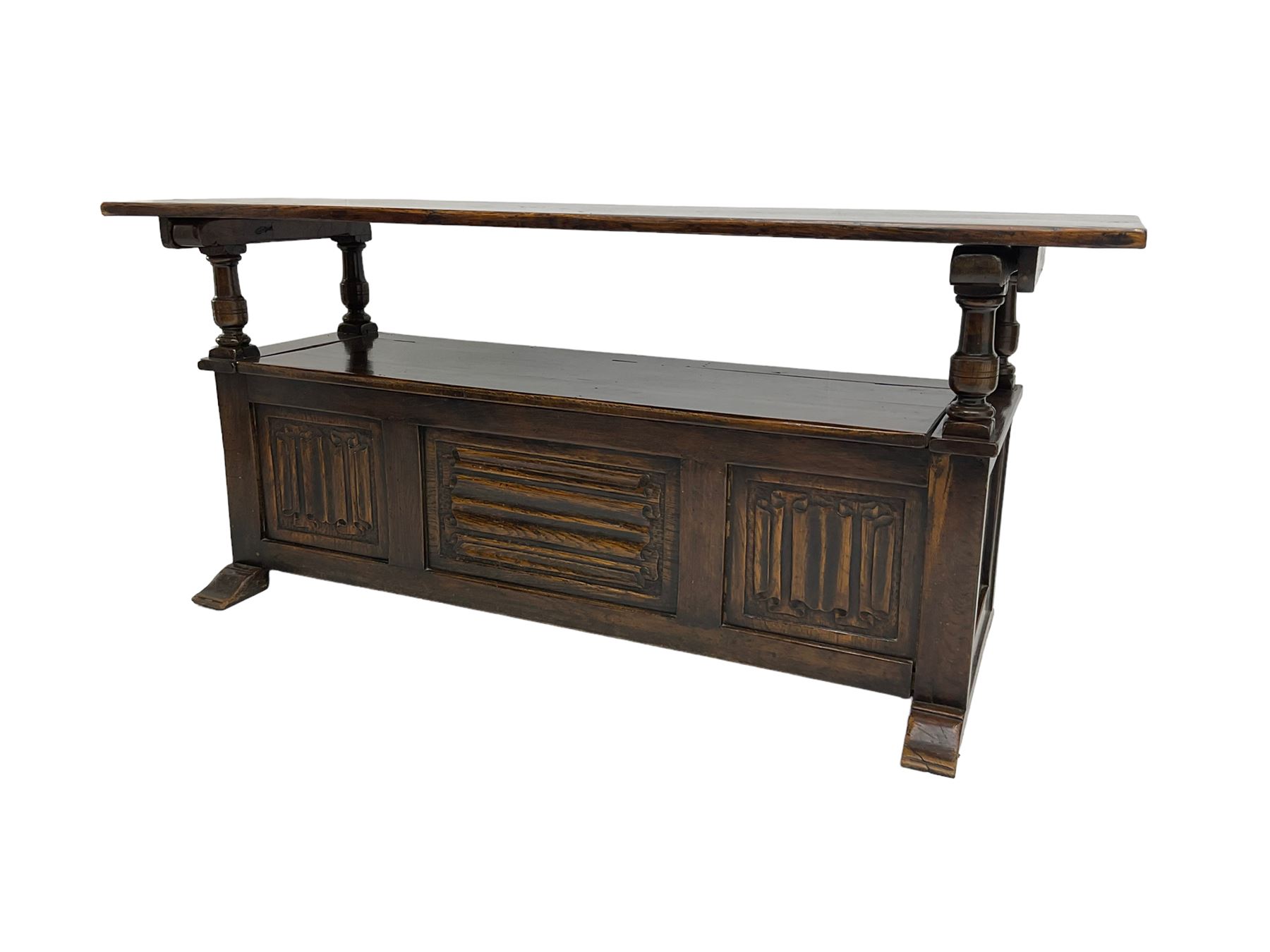 Jacobean design oak Monks bench, the front with carved linenfold panels, hinged metaphoric table back, hinged box seat compartment, on sledge feet