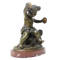 After Michel Claude Clodion (French 1738-1814): Grand Tour patinated bronze figure of a bacchic cherub, modelled dancing and playing cymbals, seated upon a naturalistic rocky base entwined with vine leaves and grapes, bearing signature, mounted on an oval red marble plinth, 19th century, W15cm H19cm