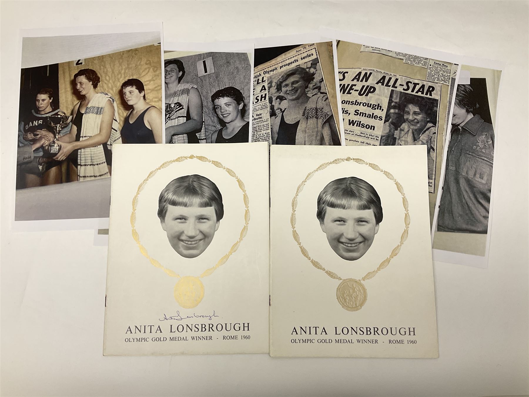 On the direct instructions of Anita Porter nee Lonsbrough Great British Olympic and Commonwealth Games gold medal winning swimmer - collection of early and international memorabilia comprising original Huddersfield Bath Club track suit top bearing eight stitched on cloth badges including British Empire & Commonwealth Games 1958 England Team, YSASA, North Eastern Counties ASA, ESSA Division 3,  English Schools Swimming Association winner etc
The swimming costume Anita wore at the 1958 Commonwealth Games in Cardiff, her first major championships, where she won two gold medals. The grey elastic on the sides, in those days, she would use to make it tighter and more streamlined.
Blue track suit from the 1960 Olympics which she wore on the podium receiving the gold medal.
1960 pool side towelling robe used at the Rome Olympics (interesting to note her name is spelt wrong on the embroidered label).
1962 Commonwealth Games pool side towelling robe used in Perth Australia when winning three Gold medals. 
It was also this year she became BBC Sports Personality of the year, the first female to do so.
Her 'lucky' pool side towel which she took with her to every event she competed in and which can be seen round her neck in many official celebratory photographs. Copies of some of these photographs are included for identification.
In addition there are two souvenir programmes of an evening event to honour Anita at The Theatre Royal Huddersfield and she has kindly signed the front cover on one of these.
