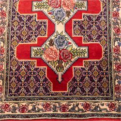 North West Persian Senneh hand-knotted runner, field with a central stepped medallion design in madder red and cream, in a series of linked lozenges filled with finely composed floral sprays and stylized roses, surrounded by densely patterned repeating geometric motifs, enclosed within a narrow main border with floral meander, flanked by multiple guard stripes, with fringe ends 
