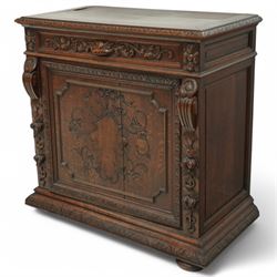 19th-century heavily carved oak baroque style cupboard with vine and floral carved frieze drawer above panelled cupboard door with floral carved appliqué (detached) flanked by symmetrically carved scroll and vine decorated sides, on bun feet 