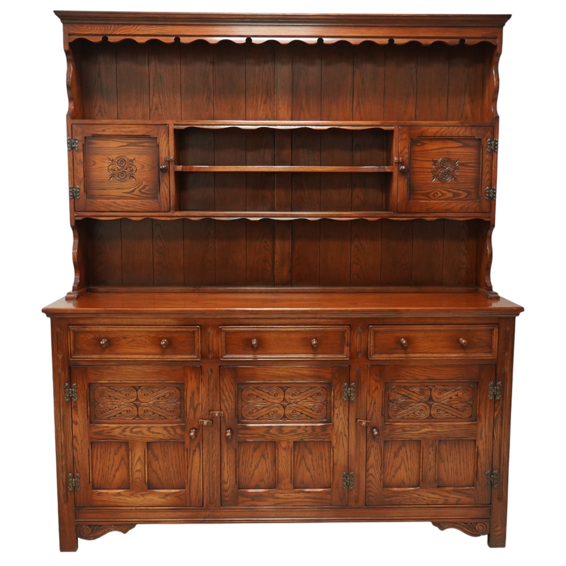 20th century oak dresser, moulded cornice above open plate rack with shaped frieze, flanked by two cupboard doors enclosing shelving, the base fitted with three drawers over three fielded panel cupboard doors, raised on bracket feet