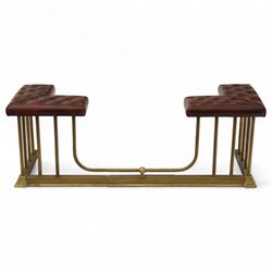 Late Victorian brass and cast iron club fender, burgundy leather buttoned seat pads, secured by bar uprights at the front and back, and a cross stretcher held in place by further bar uprights on a chamfered platform base, circa 1890, internal base dimensions 127cm 