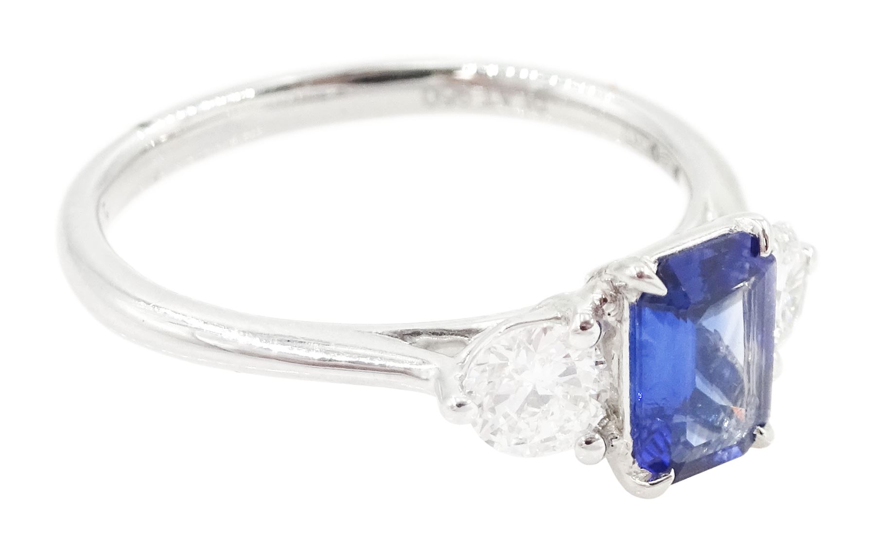 Platinum sapphire and diamond three stone ring, single emerald cut sapphire of approx 0.70 carat, either side set with two round brilliant cut diamonds, hallmarked, total diamond weight approx 0.50 carat