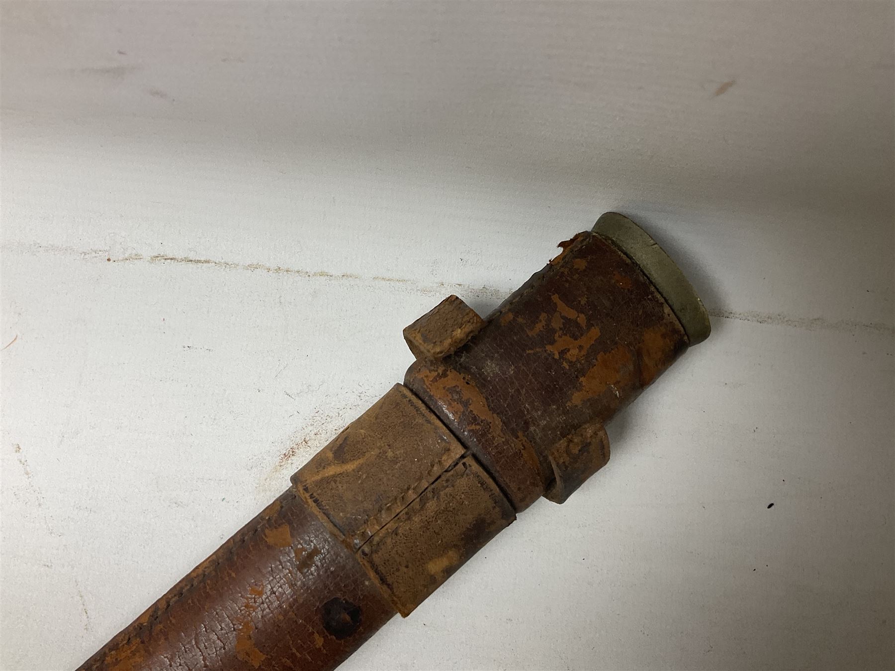 George V 1897 pattern Infantry officers sword, the 82cm single fullered blade with traces of etched detail and George V crown cipher, the ricasso marked Hawksworth Sheffield, pierced half basket hilt with George V cypher, wire-bound fish-skin grip with brass pommel and backstrap; in leather scabbard L102cm overall; together with two sectional gun cleaning rods; swagger stick made of leather strips etc