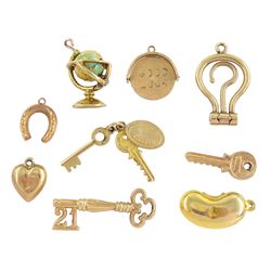 Nine 9ct gold pendant / charms including enamel globe by Georg Jensen, 21 key, bean, 'Good Luck', keys, heart and horseshoe