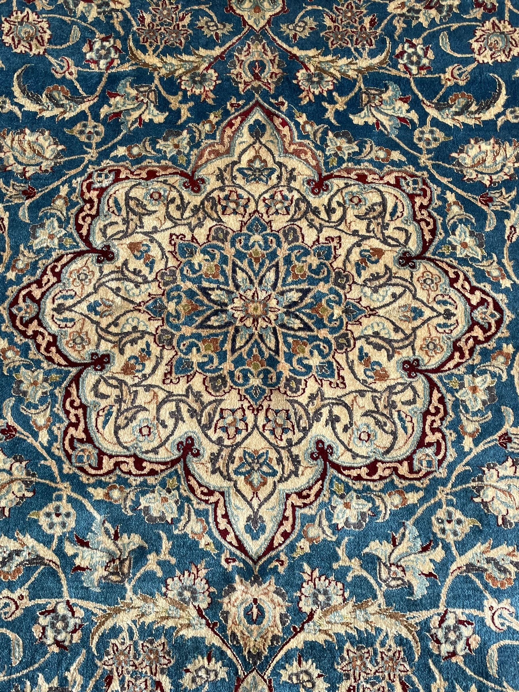 Persian Nain blue and ivory ground rug, wool with silk inlay, overall arabesque design, central medallion surrounded by interlacing and scrolled leafy branches and palmettes, the scrolling border decorated with stylised plant motifs, within guard stripes