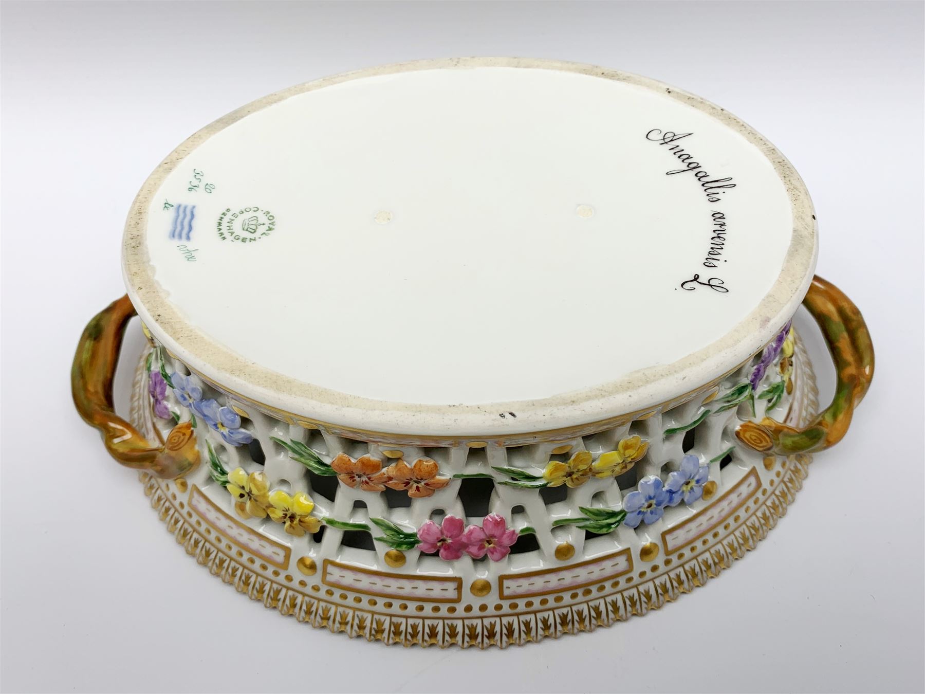 Royal Copenhagen Flora Danica basket, with naturalistically modelled vine handles and reticulated sides detailed with polychrome forget-me-nots, the interior decorated with a botanical study of 'Anagallis arvensis', sprigs and a gilt border, with printed and painted marks beneath, H8cm L26cm 

