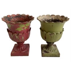 Pair of Victorian cast iron lotus garden urns, the shaped rim over lappet cast underbelly, on moulded footed base