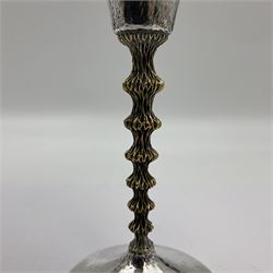 Pair of modern silver goblets by Stuart Devlin, the tapering cylindrical bowls each with spot hammered decoration and gilt interiors, the parcel gilt stems with signature textured detailing and six graduating knops, upon conforming spreading circular foot, hallmarked Stuart Devlin, London 1976, H17.7cm