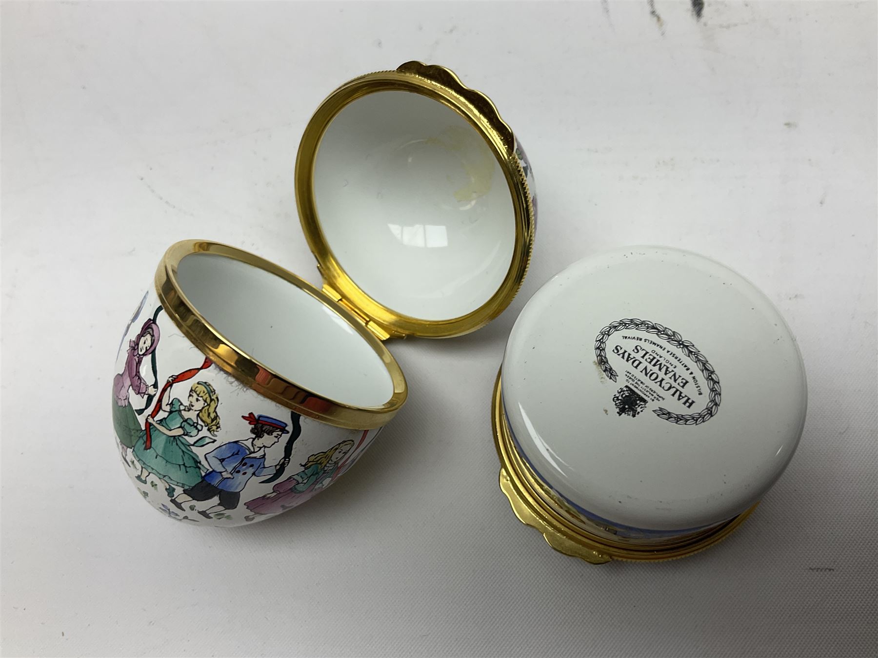 Halcyon Days bonbonniere, modelled as pink roses in a planter painted with a blue and white Japanese scene, together with five Halcyon Days enamel boxes, one a larger example depicting 'The Becket Casket' and four smaller boxes, including The 1993 Easter Egg, Happy Birthday and Statue of Liberty examples, all boxed, Becket Casket D8cm