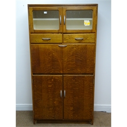  1950s oak kitchen cabinet, two glazed doors, two drawers above fall front and two cupboard doors, plinth base, W92cm, H175cm, D42cm  
