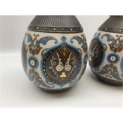 Four 19th Century Mettlach vases, comprising pair of bulbous vases, stylistically moulded with foliate scrolls, beaded borders with gilt highlights,  vase of ovoid form with taper neck, incised decoration of floral springs and flower heads in brown and turquoise on deep blue ground, and flared rim vase, the blue and terracotta ground with pale blue jewelled decoration, all with impressed makers mark beneath, tallest vase H26.5cm. 