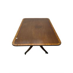 Regency style mahogany breakfast table, rectangular banded tilt-top on turned column with four splayed supports, brass hairy paw castors