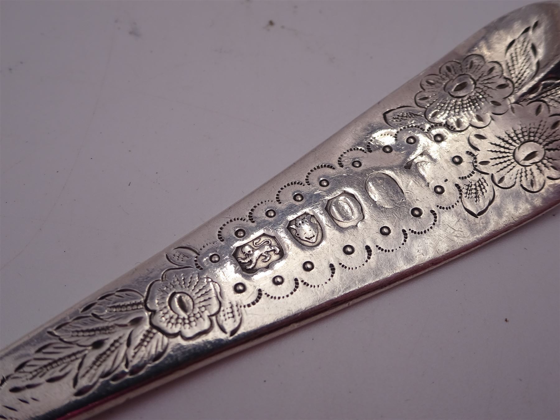 George IV silver fruit serving spoon, the bowl embossed with fruits, with engraved vine leaf decoration to handle, hallmarked London 1789, together with a very similar earlier example, hallmarks worn and indistinct