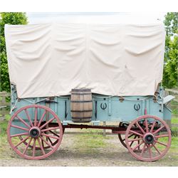 Western Covered Chuck Wagon

A large four wheeled covered wagon of timber construction, painted pale green with red painted wooden spoked wheels and a cream canvas tilt over an arched frame. The wagon has a traditional box body with covered rear compartment, front driving position, underbody turntable steering and iron fittings throughout. Fitted with external equipment details including a side mounted barrel, lidded storage chest, rope tie downs, horseshoe fittings and rear storage box.

Features

• Pale green painted timber body
• Cream canvas tilt over arched frame
• Covered rear compartment
• Front driving position
• Side mounted barrel
• External lidded storage chest
• Rear storage box
• Wooden spoked wheels
• Iron tyres
• Underbody turntable steering
• Rope tie downs
• Horseshoe fittings
• Iron hardware and brackets
• Brass restoration plaque to rear

Dimensions:
Overall length: 335 cm
Width: 170 cm
Height: 275 cm

Wheel Diameters:
Front wheels: 92 cm
Rear wheels: 112 cm

Seating:
Driver: 1
Passenger: Rear covered compartment