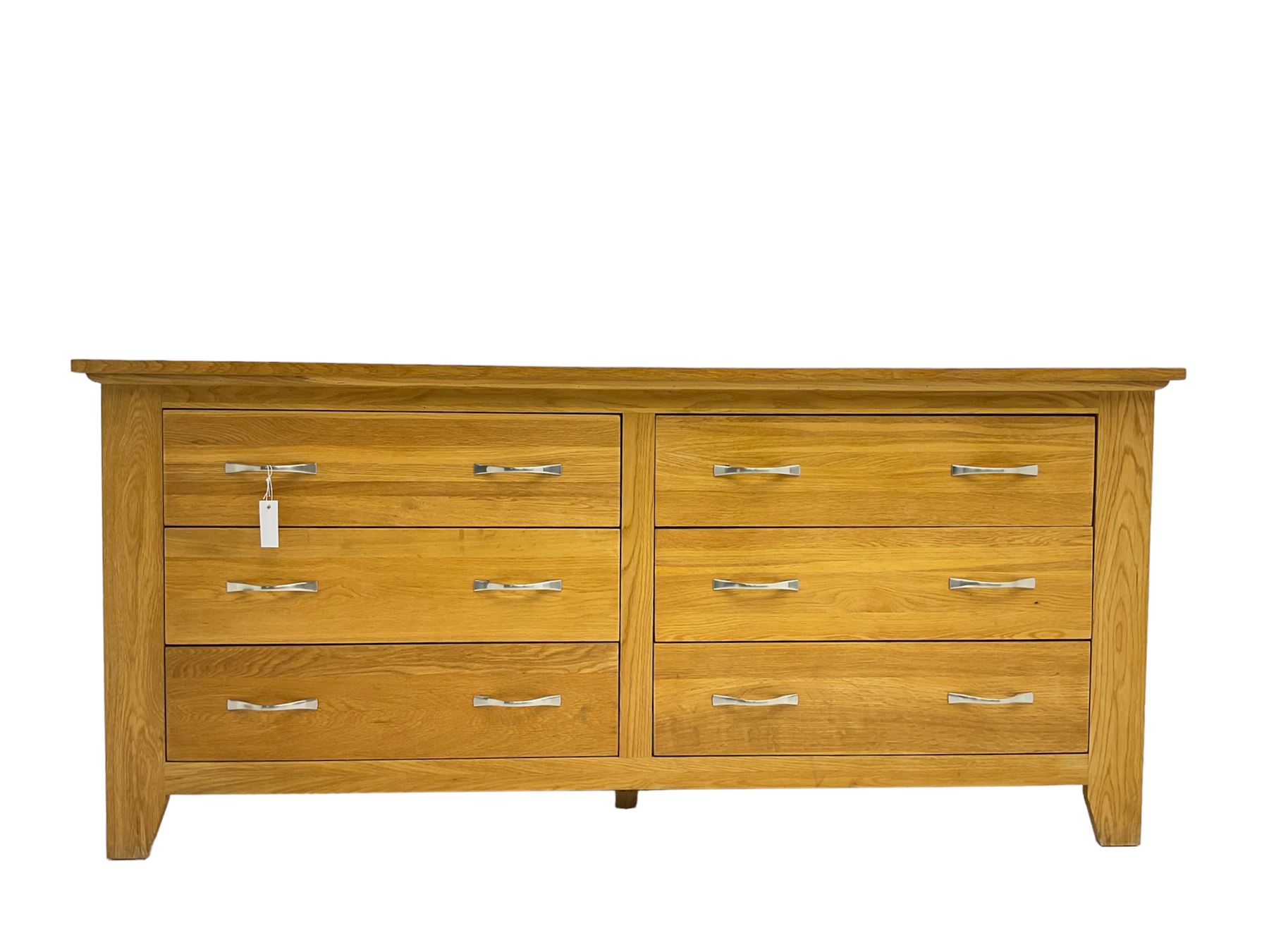 Contemporary wide oak straight-front chest, fitted with a bank of six drawers with chrome handles, on tapered feet