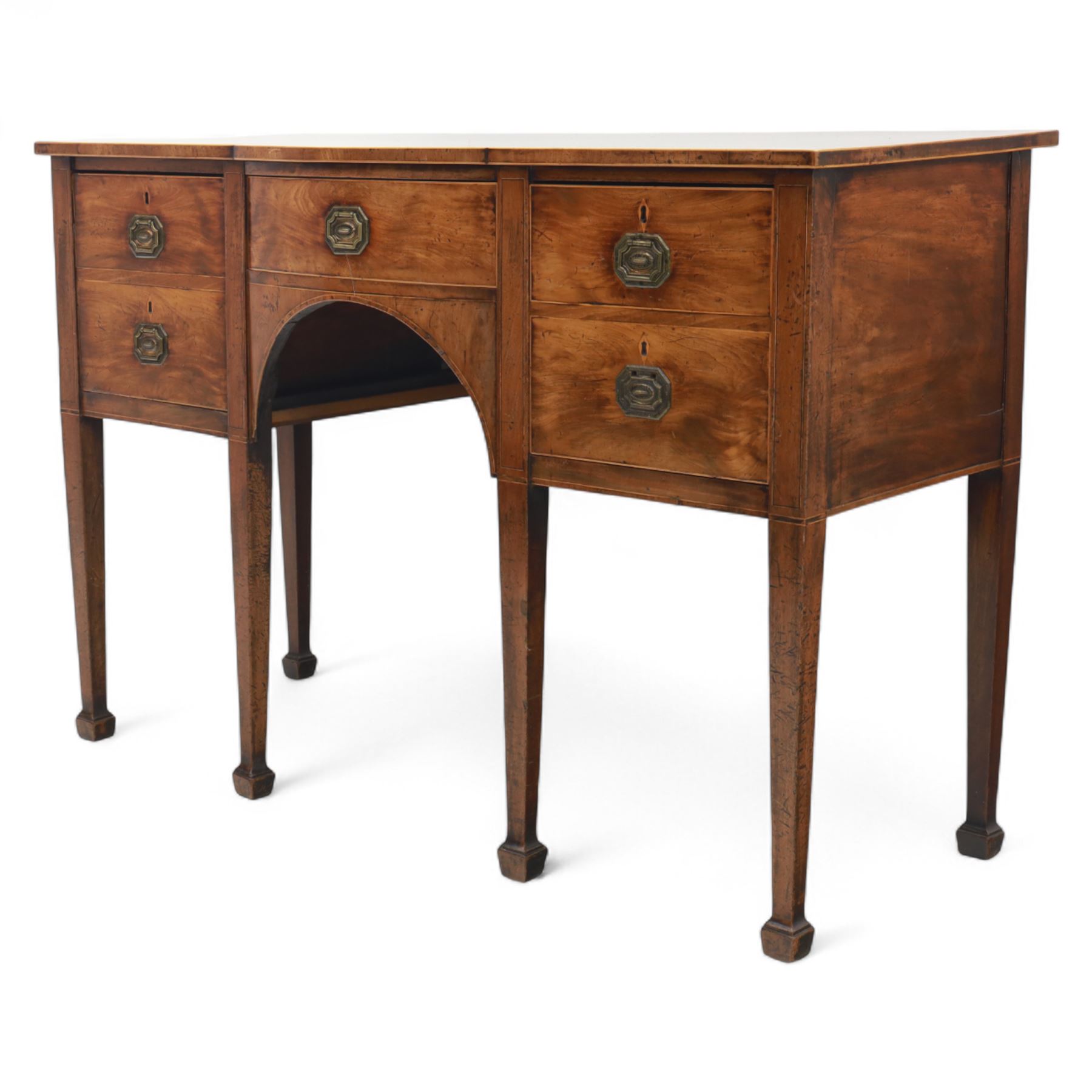 George III Sheraton-style mahogany sideboard, serpentine front fitted with central drawer and flanked by two deep drawers, raised on square tapered legs with spade feet 